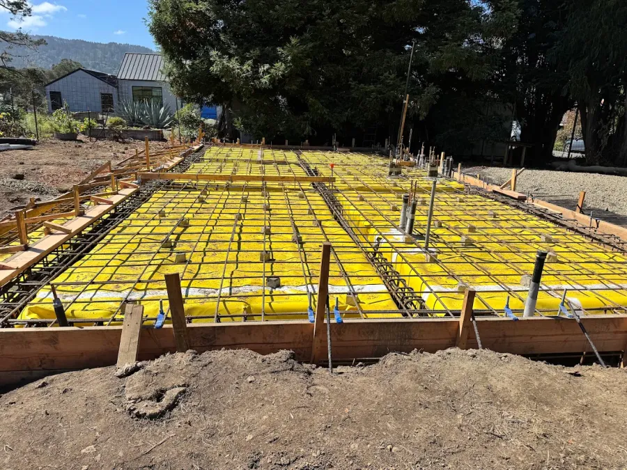 Reinforcing steel and foundation forms over a yellow membrane